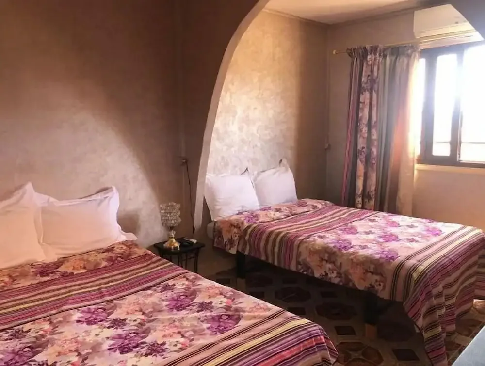 Intérieur du riad avec deux lits et un passage en arche